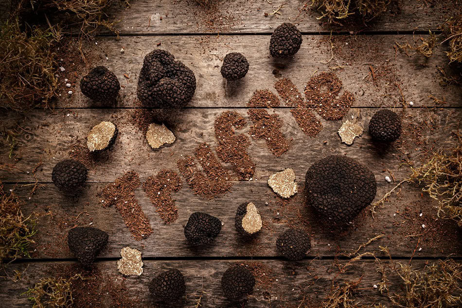Tartufi трюфели и стърготини украсяват дървена повърхност, с "Truffle" изкусно изписано във фини трюфелни люспи.